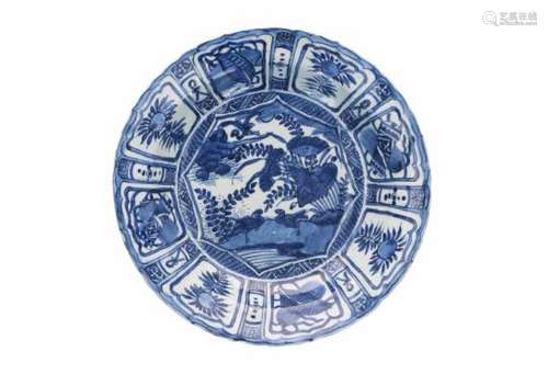 A blue and white porcelain charger, decorated with water birds and reserves depicting peaches and