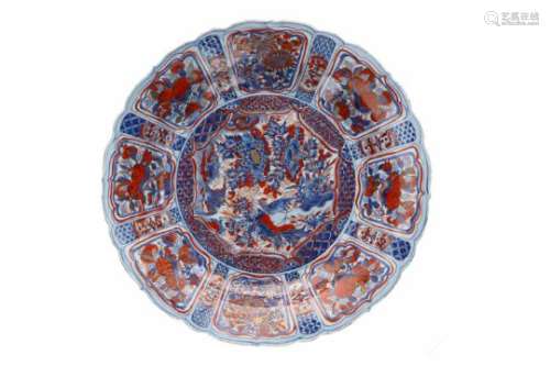 A blue and overglaze red porcelain deep charger with scalloped rim, decorated with flowers, fruits