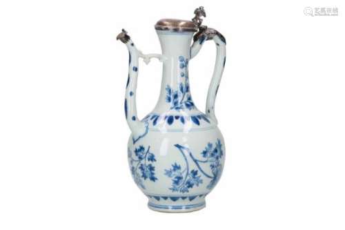 A blue and white porcelain jug with silver mounting, decorated with flowers and leaves. Unmarked.