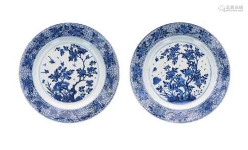 A pair of blue and white porcelain chargers, decorated with birds and a blooming tree. Marked with