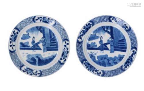 A pair of blue and white porcelain dishes, decorated with figures in a garden and flowers. Marked