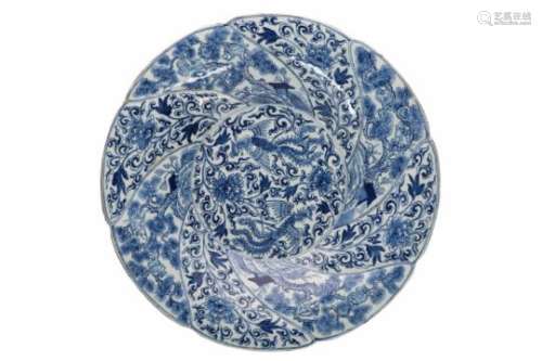 A blue and white porcelain charger with scalloped rim, decorated with phoenixes, monkeys and