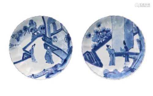 A pair of lobed blue and white porcelain deep dishes with scalloped rim, decorated with scenes of