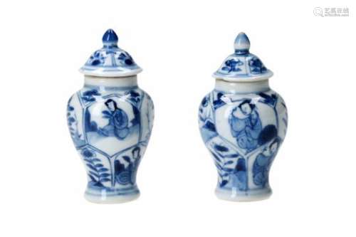 A pair of blue and white porcelain lidded miniature vases, decorated with figures and flowers.