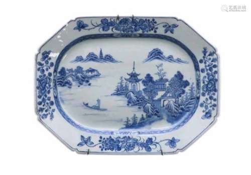 A blue and white porcelain serving dish, decorated with a mountainous river landscape and flowers.
