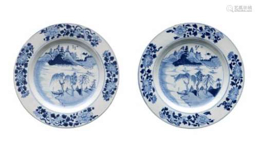 A pair of blue and white porcelain chargers, decorated with flowers and a river landscape with ships