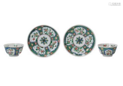 A set of two famille verte porcelain cups with saucers, decorated with flowers. Marked with