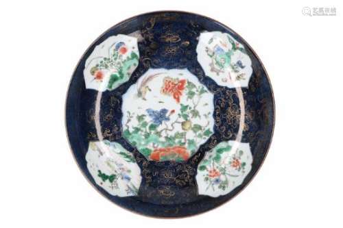 A powder blue porcelain deep dish, decorated with polychrome reserves depicting flowers, a bird,