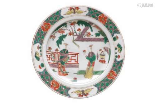 A famille verte porcelain dish, decorated with figures on a terrace, butterflies and flowers.