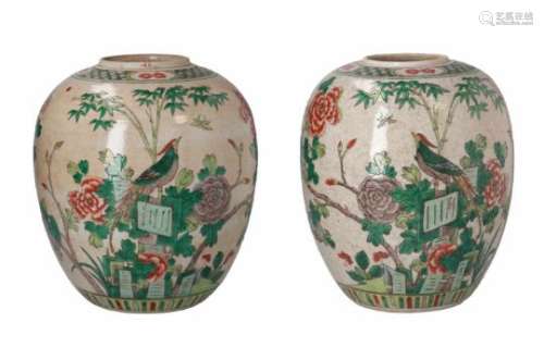 A pair of famille verte porcelain ginger jars, decorated with birds, flowers and a peacock.