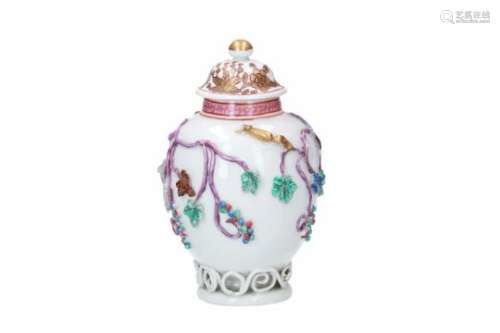 A polychrome porcelain tea caddy, decorated in relief with leaves, squirrels and fruits. Marked.