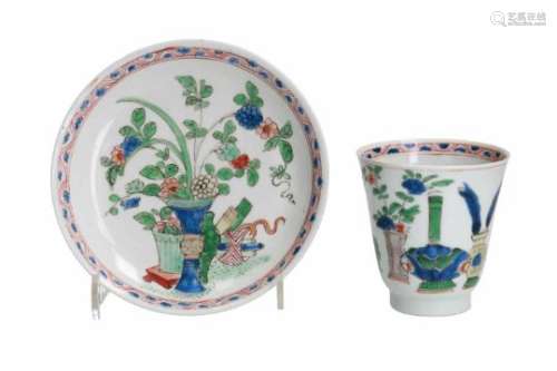 A famille verte porcelain cup with saucer, decorated with flower vases and antiquities. Marked