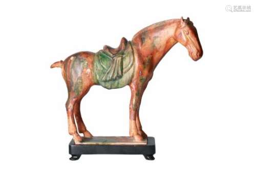 A polychrome terracotta sculpture of a horse, on wooden base. China, Tang or later.