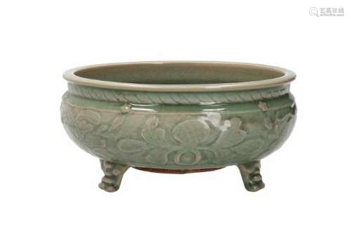 A celadon glazed stoneware tripod censer with floral relief decor. Unmarked. China, Ming.