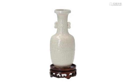 A white glazed porcelain vase with two handles on wooden base, decorated with flowers. Unmarked.