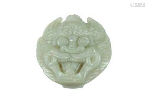 A carved jade belt buckle in the shape of a dragon head. China, 20th century.