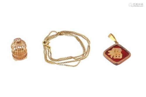 A 14-kt golden necklace with two pendants in the shape of a bird cage and a Chinese character. Total