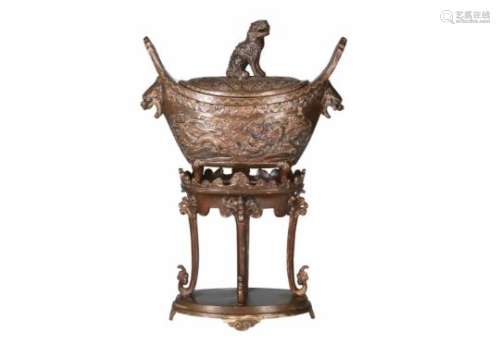 A bronze censer with lid on bronze base, decorated with a dragon and phoenix in relief. The grip