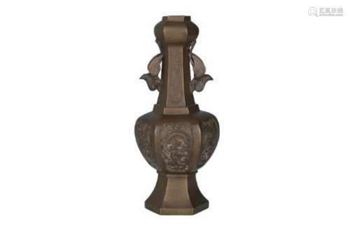 A bronze vase with carved decor of dragons. The handles in the shape of birds. Marked Qianlong on