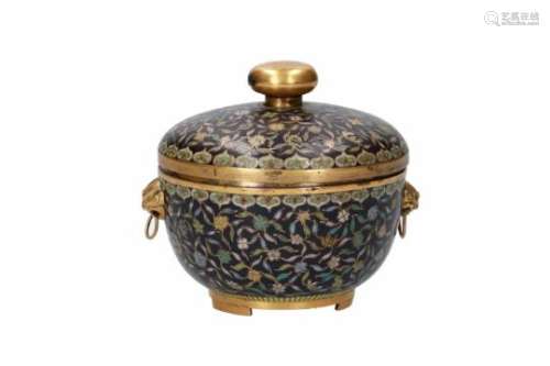 A polychrome cloisonné lidded jar, decorated with flowers. The grips in the shape of monster heads