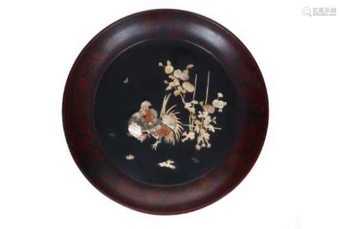 A lacquer deep charger with mother of pearl and bone relief decor of a rooster, hen, flowers and a