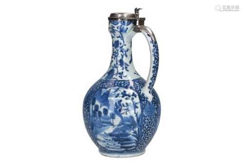 A blue and white porcelain jug with silver mounting, decorated with flowers and a landscape.