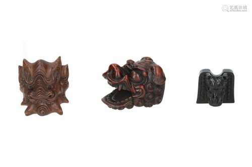 Lot of three netsuke, 1) wood, shishi head with moving jaw. Signed. H. 4 cm. 2) wood, Futen mask.