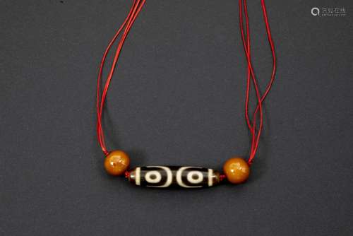 old Tibetan dzi stone and two beads of amber (?) - - Oude Tibetaanse dzi-steen en [...]