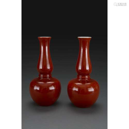 PAIRE DE VASES GOURDES À LONG COL en porcelaine etcouverte monochrome corail, à panse globulaire se prolongeant par un long col...