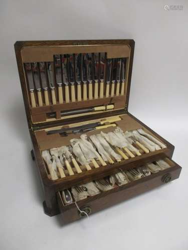 An oak canteen of silver plated cutlery, for eight persons, comprising carving utensils, two types