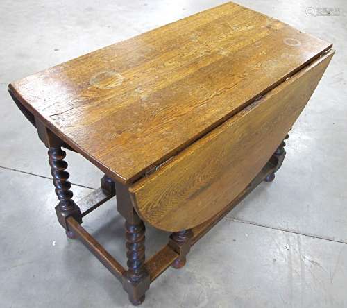 A 1920s oval oak gate leg table, moulded top, raised on barley twist supports, 53cm x 106cm x 74cm