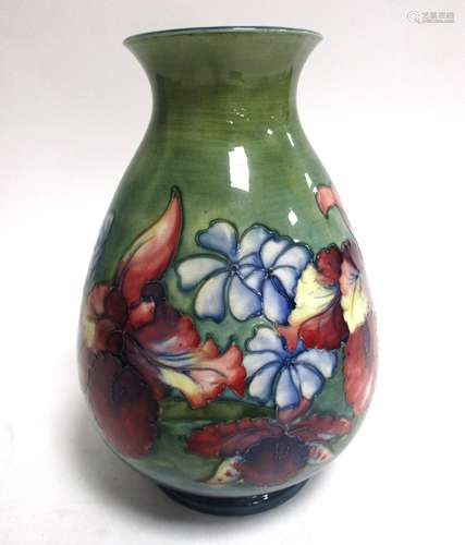 A large Moorcroft Pottery vase in the 'Orchid and Spring Flowers Pattern', on a green ground with