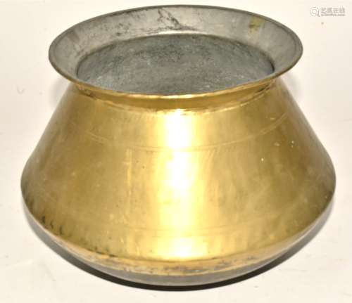 A Middle Eastern brass cooking pot, of bulbous form, on a concave base, with bands of decoration,