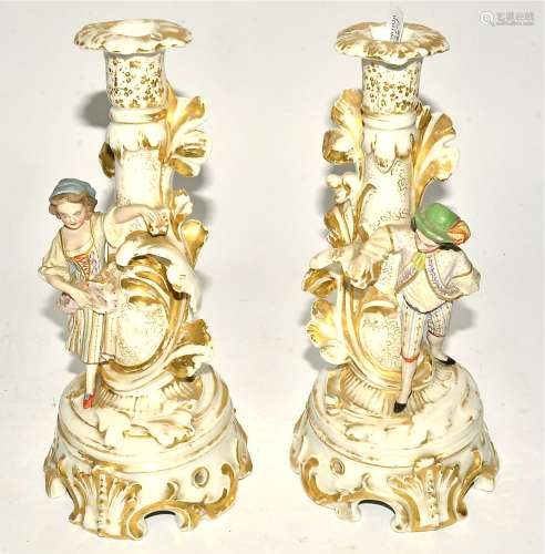 A pair of 19th Century bisque ware candlesticks with figures in 18th Century dress possibly by