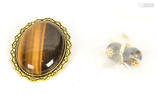 An oval tigers eye brooch, together with two spherical tigers eye earrings (2)