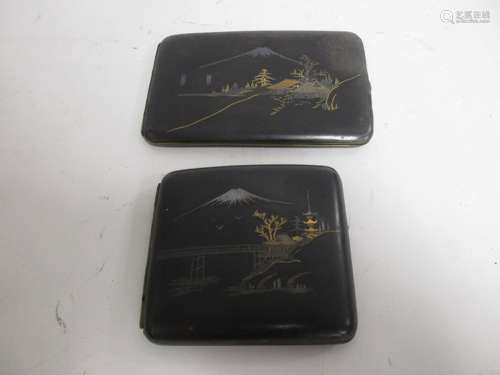 Two Japanese Shakudoware cigarette holders, both with decorative covers depicting mountainous