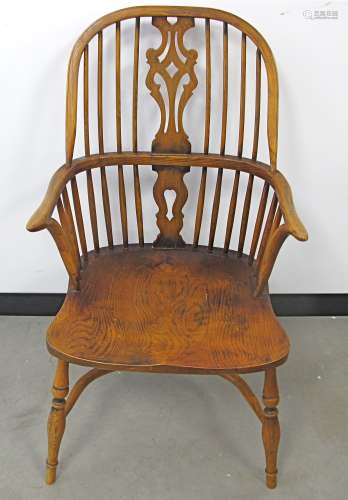 A contemporary oak Windsor arm chair, curved high back with four long spindles either side of a