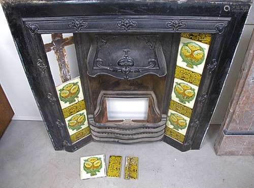 An Art Nouveau cast iron combination fireplace, blacked cast iron surround with original floral