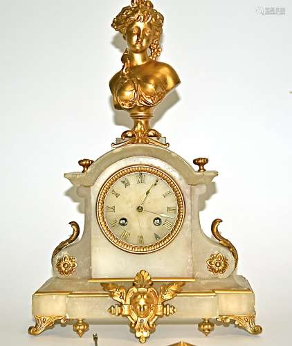 A gilt metal and onyx mantle clock surmounted by the bust of a neo-classical female, raised on