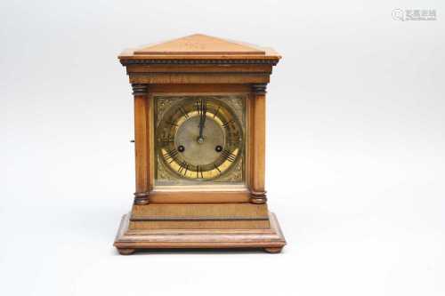 A small walnut cased mantle clock, with an embossed brass dial with Roman numerals, 30cm high, 15.