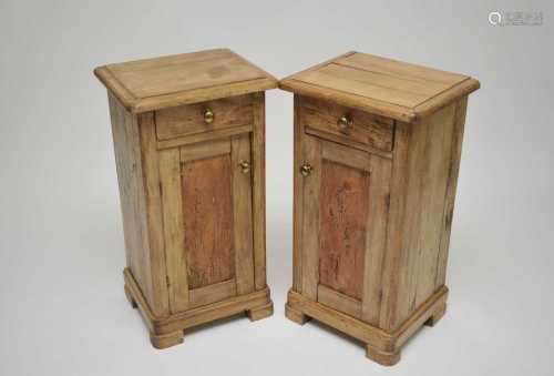 A pair of pale pine bedside cupboards, each with single short drawers and hinged panelled doors,