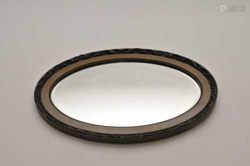 An oval wall mirror with moulded frame and bevelled plate, 64 x 86cm (maximum).