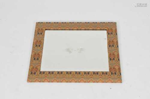 A small cushion framed wall mirror, covered in a Liberty style material, London, enclosing a