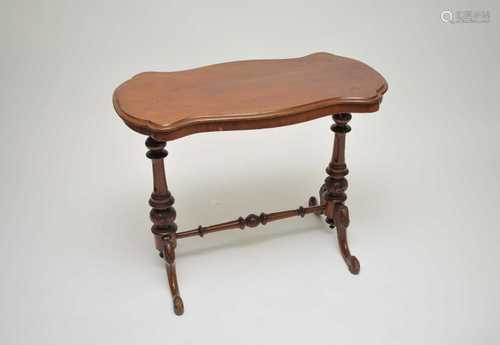 A small Victorian mahogany side table, with shaped top over a twin fluted column base and scrolled