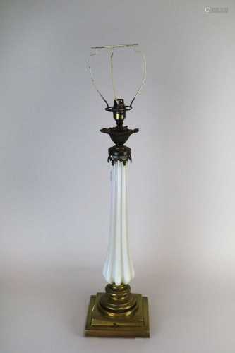 An early 20th century desk lamp, the tapering fluted opaque glass stem below a sconce with cast