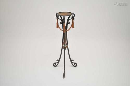 A decorative wrought iron plant stand, with painted simulated rope, raised on a scrolling tripod