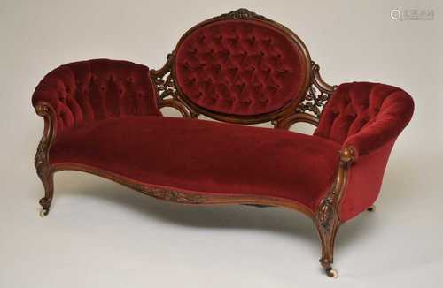 A Victorian mahogany framed sofa, the shaped back with scrolling pierced floral mounts, covered in a