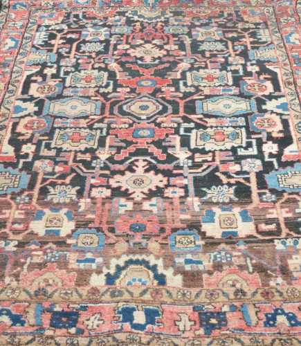 An Eastern woven wool rug, with a dark field interspersed by complicated geometric motifs, 238 x