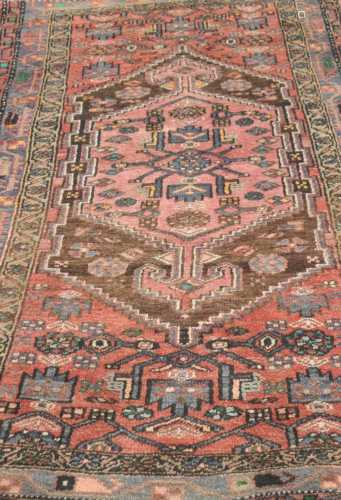 A small Eastern woven wool rug, with central geometric medallion flanked by further devices and