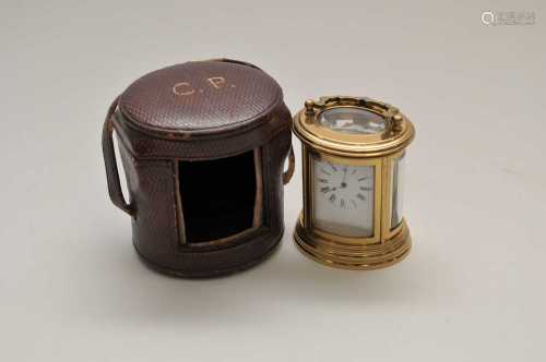 A miniature cased brass carriage clock, of oval form, the white enamel dial with black Roman